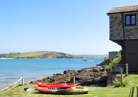 This side view of the Cottage shows our private lawn with the Kayaks that guests are welcome to use. Bantham and Thurlestone are visible across the bay. To the side of our kayak store is a hot and cold exterior shower that will revive guests who have been for a swim or out on the kayaks.